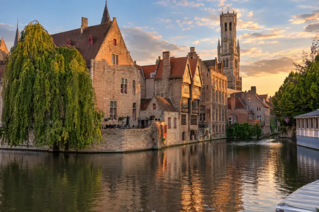 Canales y casco medieval de Brujas Canal de Brujas con edificios medievales y campanario al fondo.