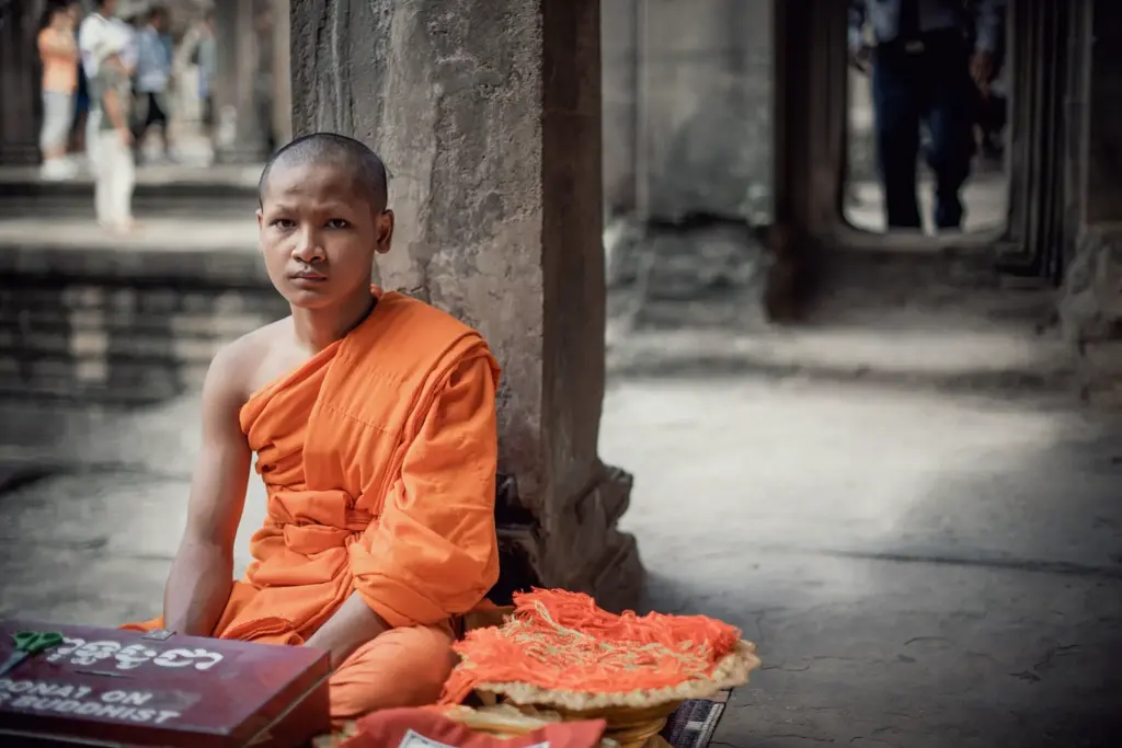 Monje budista Joven monje budista con túnica naranja en un templo de Camboya